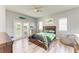 This sun-filled bedroom has wood floors, a ceiling fan, and a balcony door at 6571 Simone Shores Cir, Apollo Beach, FL 33572