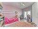 Pink-themed ' bedroom featuring a unique house bed frame, ceiling fan, and access to the backyard at 6571 Simone Shores Cir, Apollo Beach, FL 33572