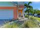 Inviting front entrance with a manicured lawn, a two-car garage, and lush landscaping, perfect for coastal living at 6571 Simone Shores Cir, Apollo Beach, FL 33572