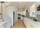 Galley kitchen features bright cabinets, updated appliances, and stylish backsplash at 6571 Simone Shores Cir, Apollo Beach, FL 33572