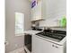 Well-lit laundry room features modern washer and dryer, storage cabinets, and shiplap accent wall at 6571 Simone Shores Cir, Apollo Beach, FL 33572