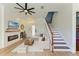 Stylish living room with wood floors, a modern fireplace, staircase, and comfortable seating, perfect for relaxation at 6571 Simone Shores Cir, Apollo Beach, FL 33572