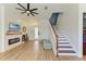 Bright and airy living room featuring modern finishes, wood floors, fireplace, and a staircase leading to the second floor at 6571 Simone Shores Cir, Apollo Beach, FL 33572