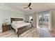 Main bedroom featuring a ceiling fan, access to a balcony and hardwood floors at 6571 Simone Shores Cir, Apollo Beach, FL 33572