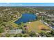 Breathtaking aerial view showcasing a serene lake, baseball field, tennis courts, and lush green surroundings at 719 21St N Ave, St Petersburg, FL 33704