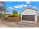 A detached garage with brown doors, a red tile roof, and exterior sconces is behind a wooden fence at 719 21St N Ave, St Petersburg, FL 33704