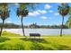 Scenic water view featuring a park bench, swaying palm trees, and a serene lake under a clear sky at 719 21St N Ave, St Petersburg, FL 33704