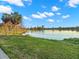 Picturesque lake view showcasing lush green grass, calm waters, and a vibrant skyline in the distance at 719 21St N Ave, St Petersburg, FL 33704