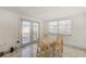 Bright dining area with a natural wood table, bathed in natural light from a large window at 7635 Sue Ellen Dr, Port Richey, FL 34668