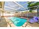 This is a swimming pool in a screened in pool with an open air roof at 7635 Sue Ellen Dr, Port Richey, FL 34668