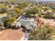 An aerial view of a house with a large backyard, pool with enclosure, and mature trees at 7948 Floral Dr, Weeki Wachee, FL 34607