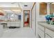 Bright bathroom with white tile floors, dual vanities, and a glimpse into a connecting room at 7948 Floral Dr, Weeki Wachee, FL 34607