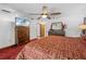 Inviting bedroom featuring red carpet, stylish wooden furniture, ceiling fan, and tasteful decor at 7948 Floral Dr, Weeki Wachee, FL 34607