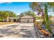 Front exterior featuring a two-car garage, brick driveway and manicured landscaping at 7948 Floral Dr, Weeki Wachee, FL 34607