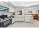 Bright kitchen with stainless steel appliances, tiled floor, and white countertops at 7948 Floral Dr, Weeki Wachee, FL 34607