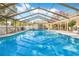 A large pool with a screen enclosure, with a seating and barbecue area outside the enclosure at 7948 Floral Dr, Weeki Wachee, FL 34607