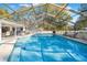 A large pool with a screen enclosure, with seating areas outside the enclosure at 7948 Floral Dr, Weeki Wachee, FL 34607