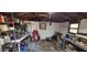 Untidy shed interior cluttered with tools, equipment, and storage boxes, with exposed roof beams overhead at 8006 N Temple Pl, Tampa, FL 33617