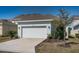 Charming one-story home showcasing a manicured lawn, a two-car garage, and mature landscaping at 811 Winterside Dr, Apollo Beach, FL 33572