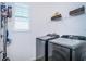 Convenient laundry room has modern washer and dryer, plus shelving for organized storage at 811 Winterside Dr, Apollo Beach, FL 33572