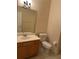 Neutral bathroom with tile floor, toilet, and a wooden vanity at 8137 Cottonwood Ct, Seminole, FL 33776