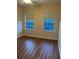 Bedroom showcasing two windows and beautiful wood floors at 8137 Cottonwood Ct, Seminole, FL 33776