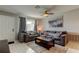 Comfortable living room with tile floors, neutral paint, a ceiling fan and large window dressed with gray curtains at 8417 Moulton Dr, Port Richey, FL 34668