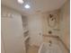 Bathroom featuring a bathtub with shower head, glass shelves, and open storage cubbies at 8765 Bardmoor Blvd # 107, Seminole, FL 33777