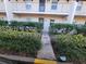 Condo exterior with walkway leading to door, featuring lush green landscaping at 8765 Bardmoor Blvd # 107, Seminole, FL 33777