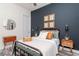 This decorated bedroom features a dark-colored wall with wall art, a decorative mirror, and overhead lighting at 9250 Rhea Dr, Odessa, FL 33556