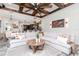 Spacious living room featuring a beamed ceiling, a ceiling fan, and an open layout to the kitchen at 9250 Rhea Dr, Odessa, FL 33556