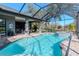 Beautiful in-ground pool with attached spa, screened enclosure, and a view of the outdoor living area at 9250 Rhea Dr, Odessa, FL 33556