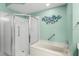 Bathroom featuring a shower with glass door and built-in tub at 1028 Mcdaniel St # 68, Sun City Center, FL 33573