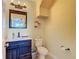 A well-lit powder room featuring a dark wood vanity, white countertop and toilet at 11846 Thicket Wood Dr, Riverview, FL 33579