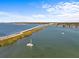Scenic aerial view of a bridge over tranquil waters, lined with lush green foliage and distant waterfront homes at 1201 Bay Dr, Belleair Beach, FL 33786
