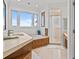 Bright bathroom featuring a soaking tub, step-in shower, and granite countertops, exuding modern elegance at 1201 Bay Dr, Belleair Beach, FL 33786