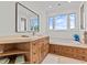 Bright bathroom featuring a soaking tub, step-in shower, and granite countertops, exuding modern elegance at 1201 Bay Dr, Belleair Beach, FL 33786