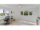 Bright bedroom featuring hardwood floors, large windows, white trim, a ceiling fan and an adjacent work space at 1201 Bay Dr, Belleair Beach, FL 33786