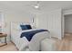 Cozy bedroom featuring a bed with blue pillows and a blue throw, and a closet with a white door at 1201 Bay Dr, Belleair Beach, FL 33786