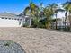 Paver driveway leads to a two-car garage, complementing the lush tropical landscaping around this lovely home at 1201 Bay Dr, Belleair Beach, FL 33786