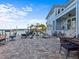 Exterior facade of a waterfront property featuring an outdoor patio, landscaping and a fountain feature at 1201 Bay Dr, Belleair Beach, FL 33786