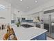 Contemporary kitchen features a large island with seating, stainless steel appliances, and a blue tile backsplash at 1201 Bay Dr, Belleair Beach, FL 33786