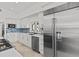 Bright kitchen with stainless steel appliances, white cabinetry, stone countertops, and decorative backsplash at 1201 Bay Dr, Belleair Beach, FL 33786
