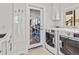 Well-equipped laundry room with modern washer and dryer, plus storage and sink at 1201 Bay Dr, Belleair Beach, FL 33786