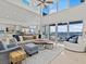 Spacious living room with soaring ceilings, waterfront views, modern furnishings, and abundant natural light at 1201 Bay Dr, Belleair Beach, FL 33786