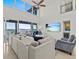 Open living room with a large sectional sofa, water views, and a decorative fireplace at 1201 Bay Dr, Belleair Beach, FL 33786