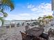 A beautifully designed backyard with outdoor kitchen, dining area, lounge seating, pool and gorgeous waterfront views at 1201 Bay Dr, Belleair Beach, FL 33786