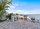 An outdoor kitchen with built-in grill, refrigerator, and sink with a view of the water at 1201 Bay Dr, Belleair Beach, FL 33786