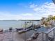 Beautiful outdoor patio featuring lounge chairs, landscaping, a fountain feature and a water view at 1201 Bay Dr, Belleair Beach, FL 33786