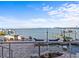 Beautiful outdoor patio featuring lounge chairs, landscaping, a fountain feature, an outdoor kitchen, and a water view at 1201 Bay Dr, Belleair Beach, FL 33786